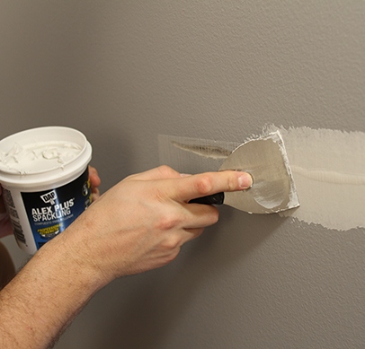 After the adhesive has set, sand the area smooth and paint to match the rest of the wall.