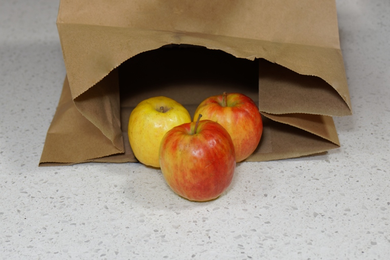 Apples can be ripened by placing them in a paper bag with a banana for two to three days.