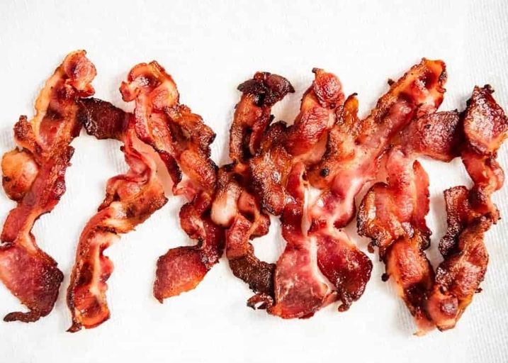 If you're looking for a way to cook bacon that results in evenly cooked, crisp bacon without any fuss, then cooking bacon on a cooling rack in the oven is the way to go.