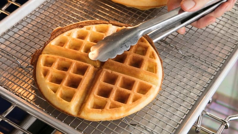 The best way to keep your waffles warm is to place them on a wire rack on a baking sheet in a preheated oven.